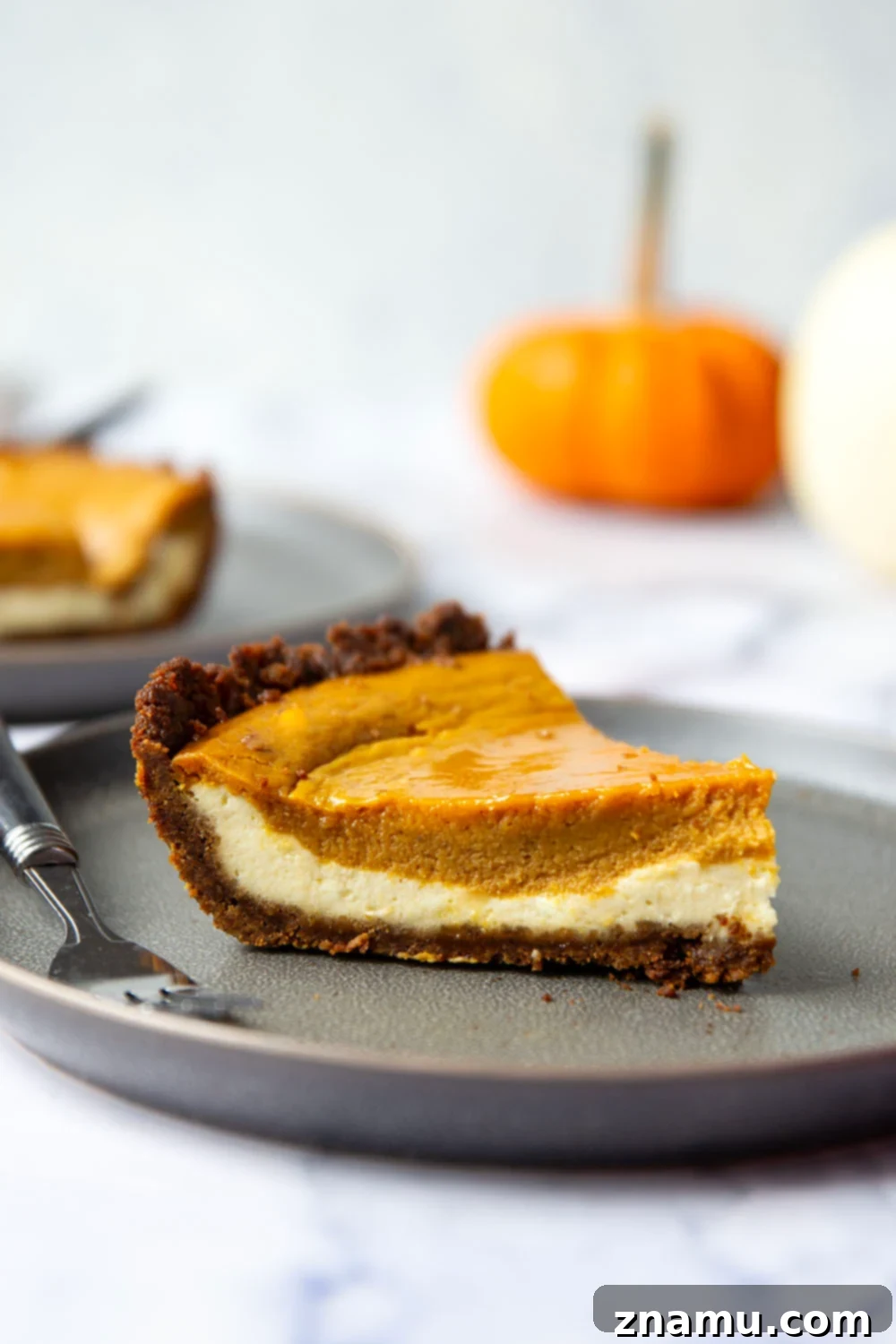 Harvest Pumpkin Cheesecake Delight 2 A slice of pumpkin cheesecake pie with a gingersnap crust, perfect for holiday tables.
