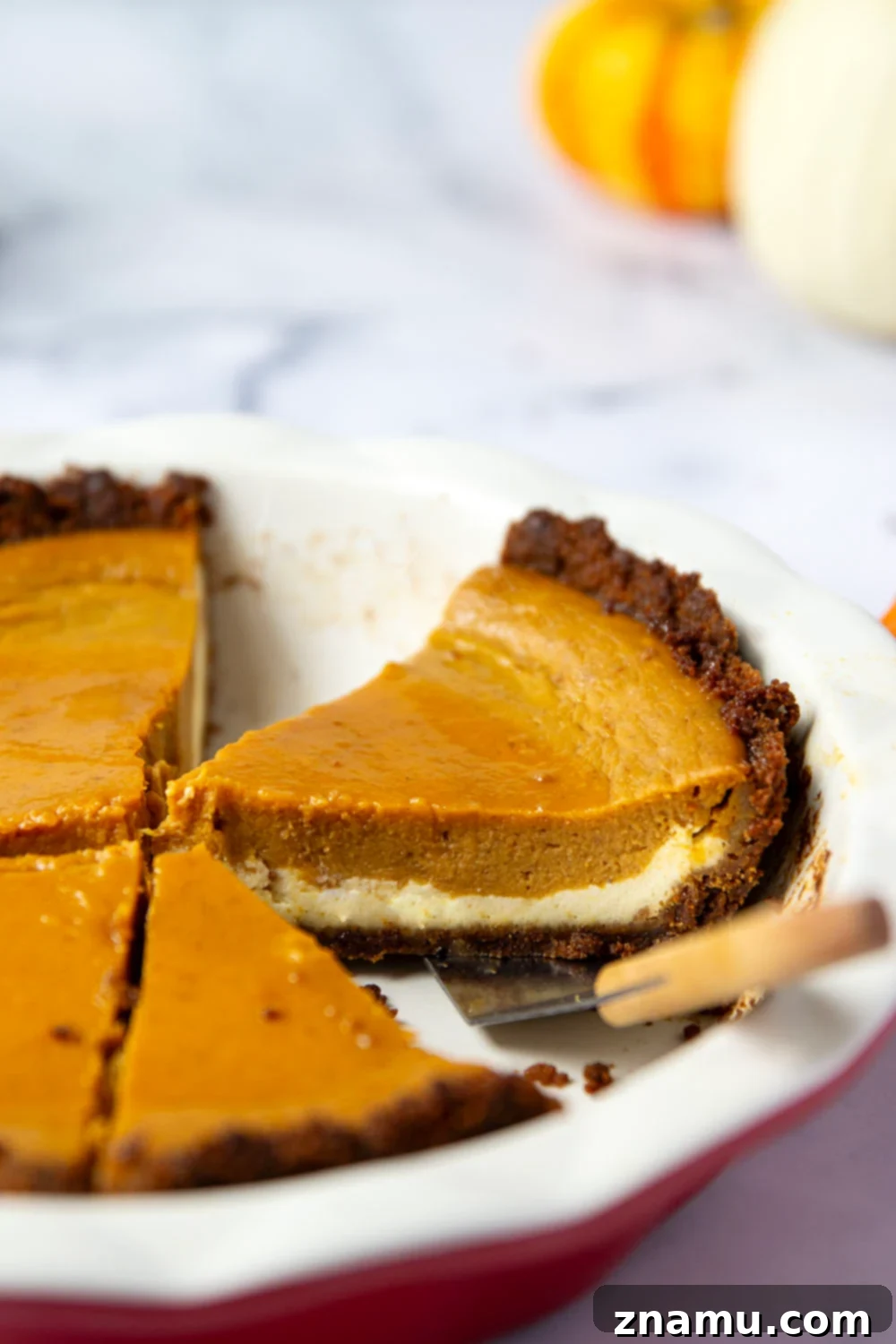 Harvest Pumpkin Cheesecake Delight 6 A beautifully sliced pumpkin cheesecake pie, showcasing its distinct layers.