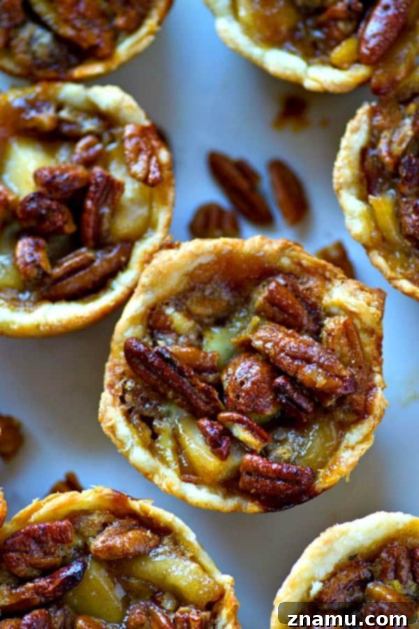 Caramel Apple Pecan Mini Pies 4 Caramel apple pie filling being topped with pecan mixture for mini pies