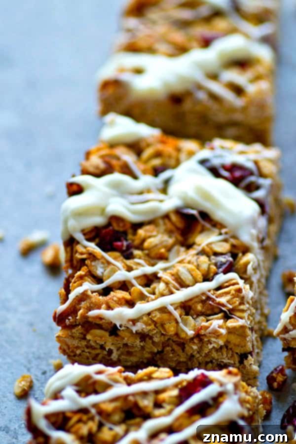 Heavenly White Chocolate Cranberry Granola Bars 3 Close-up shot of the soft and chewy texture of a White Chocolate Cranberry Bliss Granola Bar, showcasing the oats, dried cranberries, and generous white chocolate drizzle.