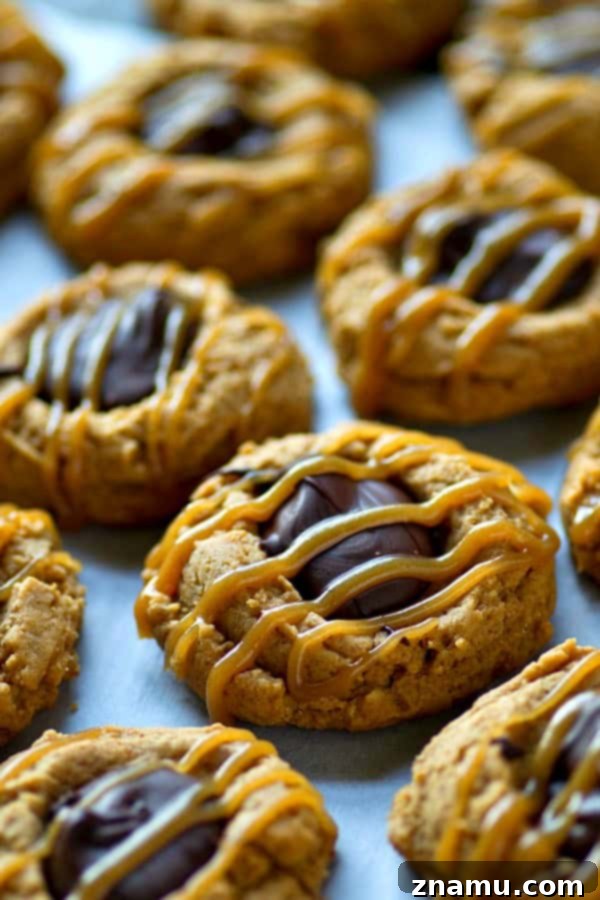Peanut butter cookies with thumbprint indents ready for filling
