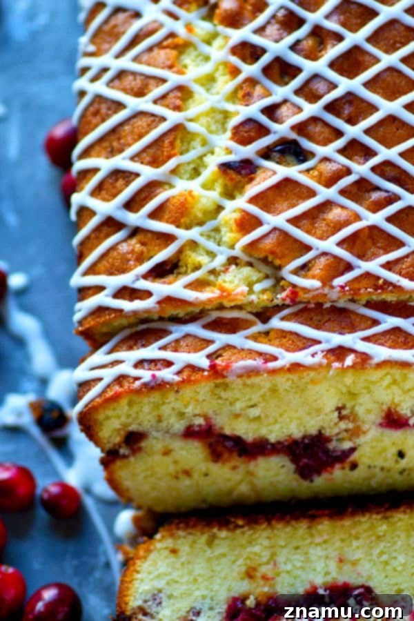 Almond Pound Cake with Cranberry Swirl 3 Close-up of a glazed almond pound cake, revealing the beautiful red cranberry swirl peeking through the golden cake, a truly festive treat.