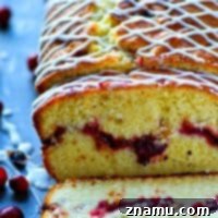 Almond Pound Cake with Cranberry Swirl 7 A close-up shot of a single slice of cranberry swirl almond pound cake, showcasing the intricate swirl and the moist crumb, topped with a delicate glaze.