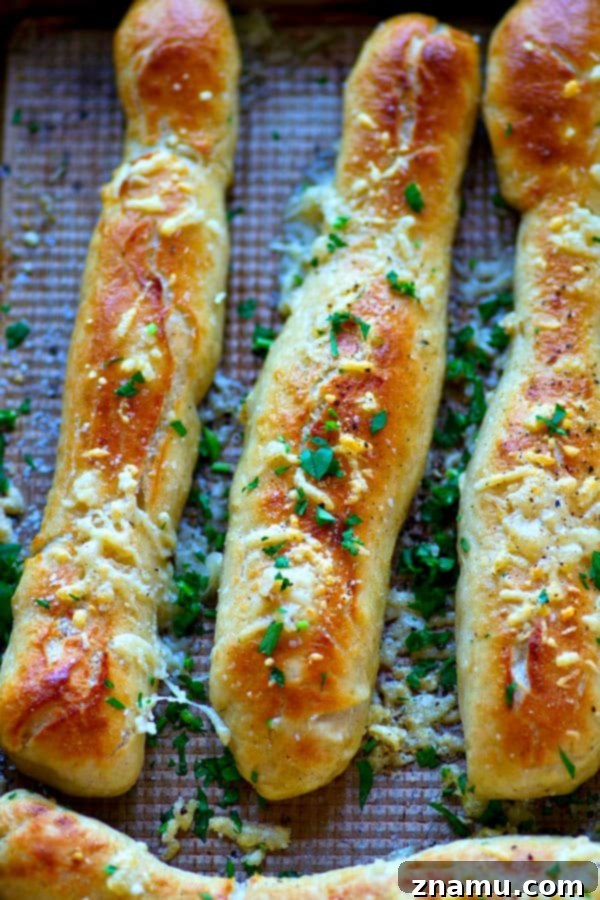 Close-up of golden brown Soft Pretzel Breadsticks with melted garlic butter and Parmesan