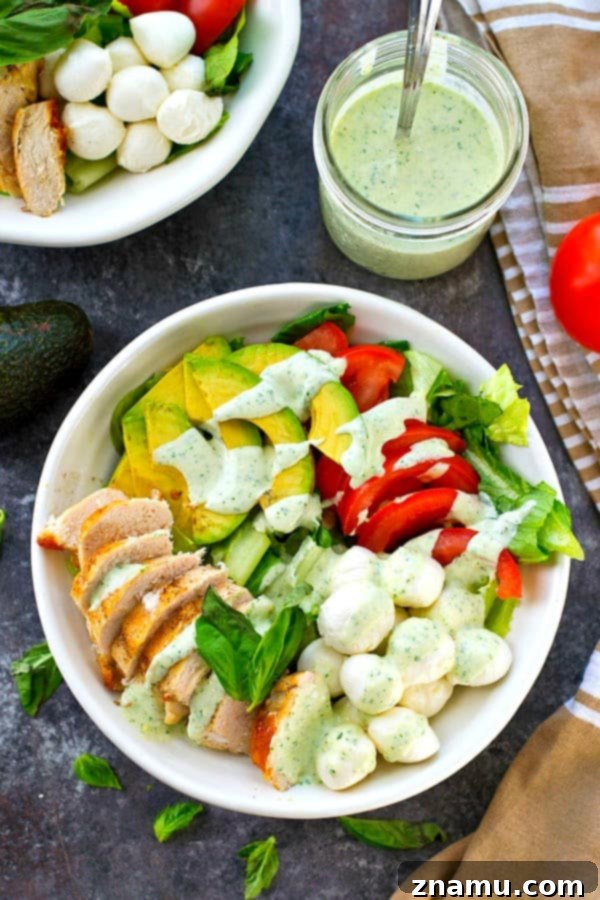 Pan-seared chicken, avocado, and a creamy flavorful pesto dressing spice up this colorful and massively flavor-packed caprese salad!