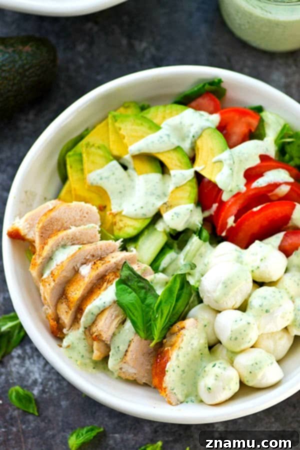 Pan-seared chicken, avocado, and a creamy flavorful pesto dressing spice up this colorful and massively flavor-packed caprese salad!