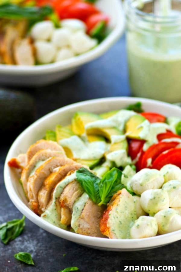 Pan-seared chicken, avocado, and a creamy flavorful pesto dressing spice up this colorful and massively flavor-packed caprese salad!