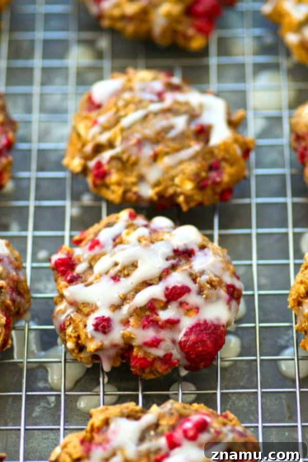 Dreamy Raspberry Cheesecake Breakfast Cookies 4 Overhead shot of freshly baked Raspberry Cheesecake Breakfast Cookies cooling on a rack, some drizzled with glaze.