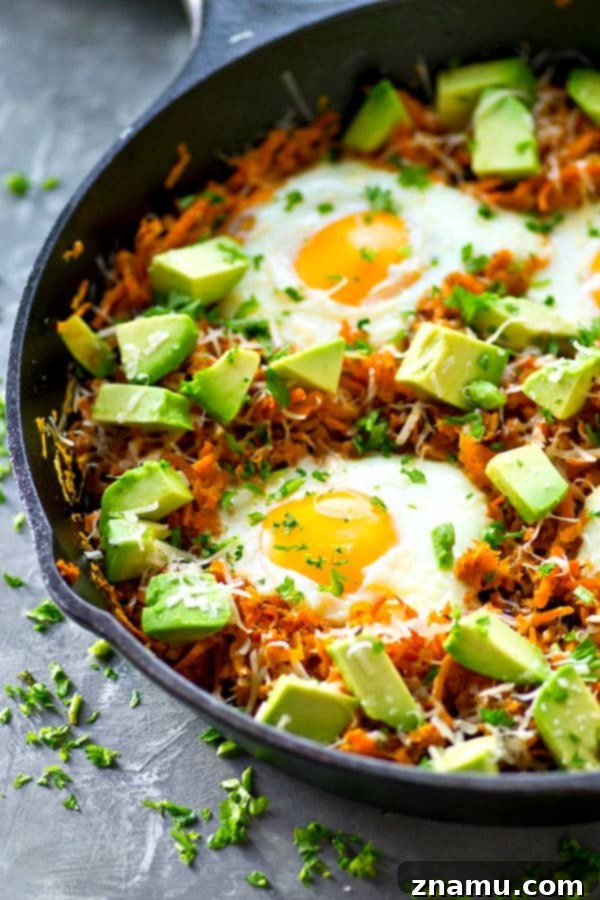 Close-up of perfectly baked eggs in a sweet potato hash brown skillet