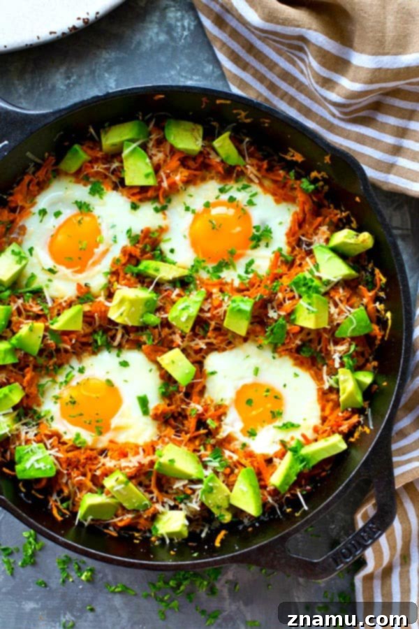 Overhead view of a breakfast skillet with sweet potatoes and eggs, ready for toppings