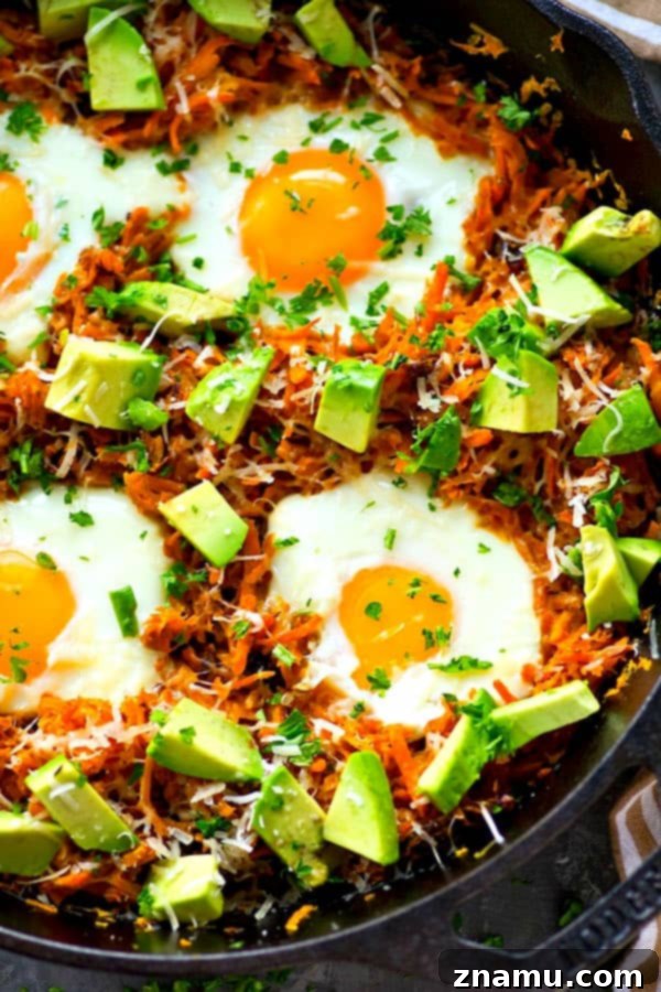 Close-up of a sweet potato breakfast skillet with avocado and Parmesan, ready to be served