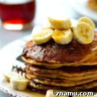 Thick and fluffy banana buttermilk pancakes are generously coated in a homemade cinnamon crunch topping for the ultimate pancake combo.---you will not be able to stack these high enough!