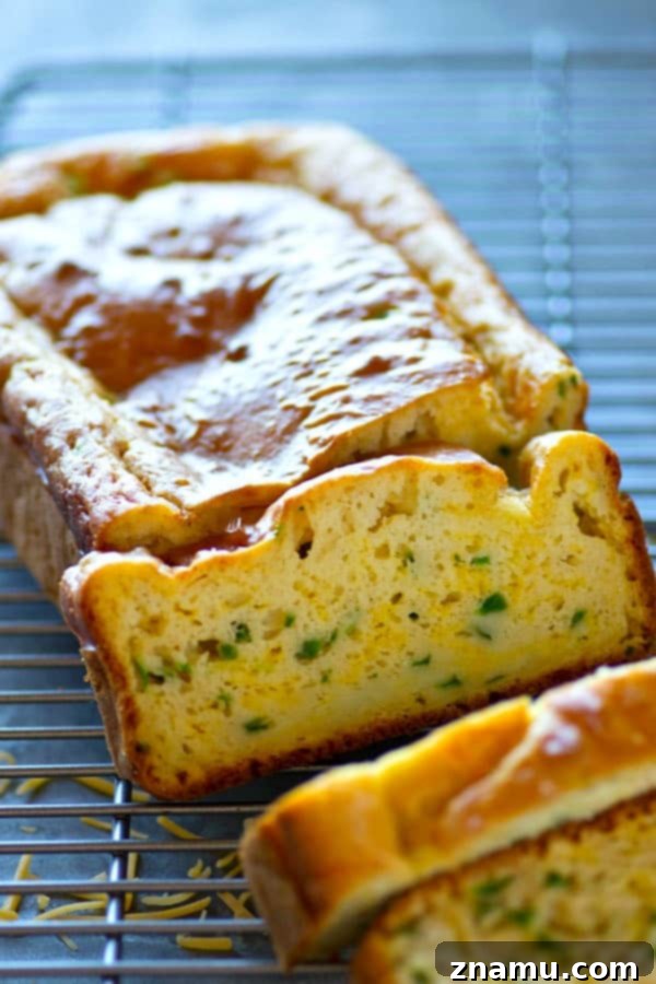 Zesty Cheddar Jalapeno Quick Loaf 3 Several loaves of golden-brown Cheesy Jalapeño Cheddar Quick Bread displayed on a rustic wooden surface, highlighting their inviting texture.