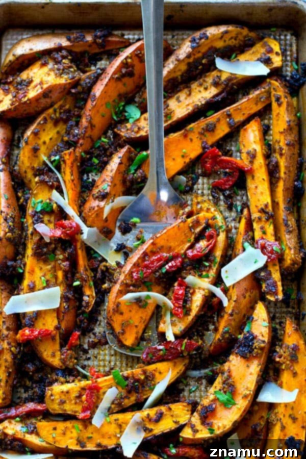 Tangy Pesto Roasted Sweet Potato Wedges 5 A large baking sheet filled with a generous batch of perfectly roasted sun-dried tomato pesto sweet potato wedges, ready to serve.