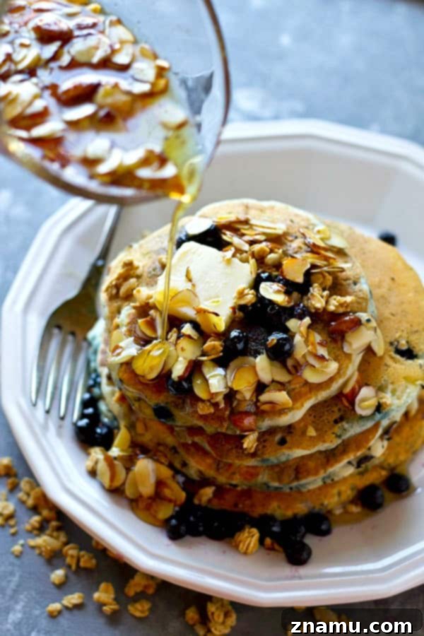 Golden Blueberry Granola Stacks, Drizzled with Almond Syrup 5 Blueberry granola pancakes with almond syrup, ready to be served