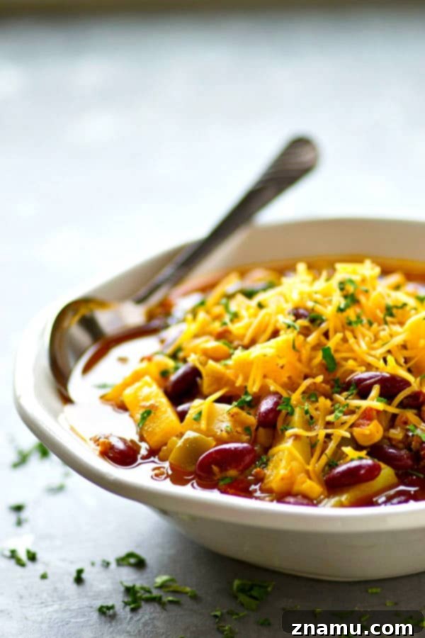 Tropical Twist Instant Pot Beef Chili 5 A bowl of Instant Pot Pineapple Beef Chili topped generously with shredded cheddar cheese, ready to eat.