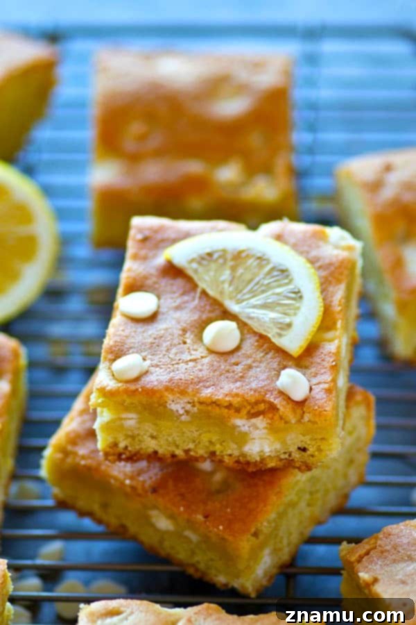 Close-up of freshly baked White Chocolate Lemon Blondies with melted white chocolate chips, showcasing a soft and chewy texture.