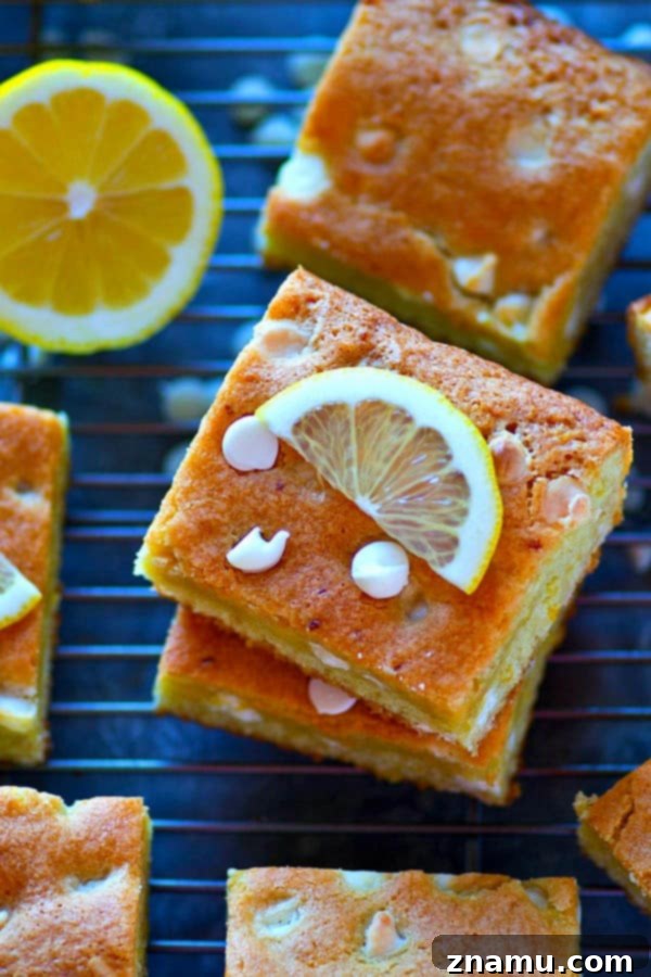 A close-up of a single White Chocolate Lemon Blondie, showing its thick, chewy texture and visible white chocolate chunks.