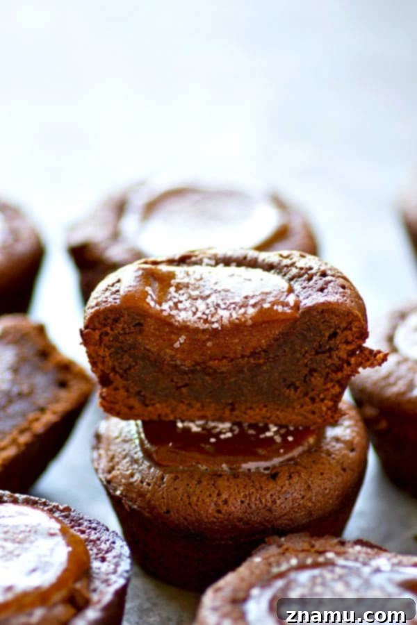 An irresistible dark chocolate salted caramel brownie cup, showcasing its gooey center and sprinkle of coarse salt.