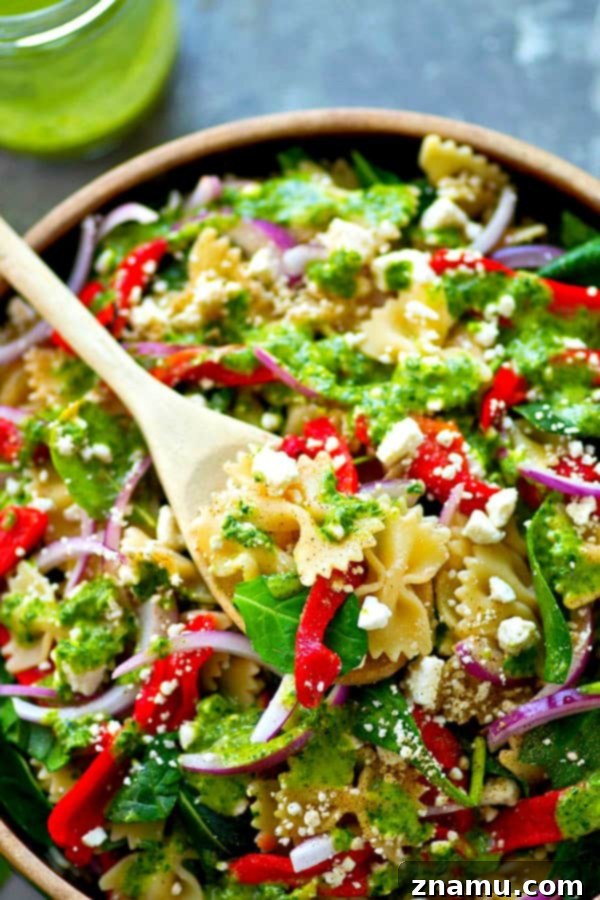Mediterranean Roasted Red Pepper Feta Pasta Salad with Basil Vinaigrette 4 Hand drizzling fresh basil vinaigrette over the vibrant Roasted Red Pepper Feta Pasta Salad