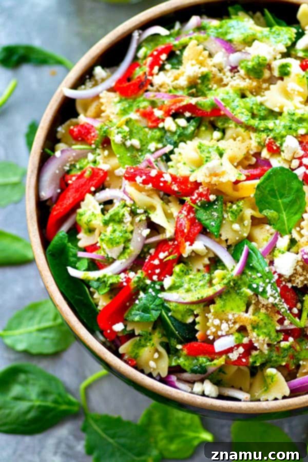 Mediterranean Roasted Red Pepper Feta Pasta Salad with Basil Vinaigrette 5 Large bowl of Roasted Red Pepper Feta Pasta Salad ready to be served, garnished with fresh basil