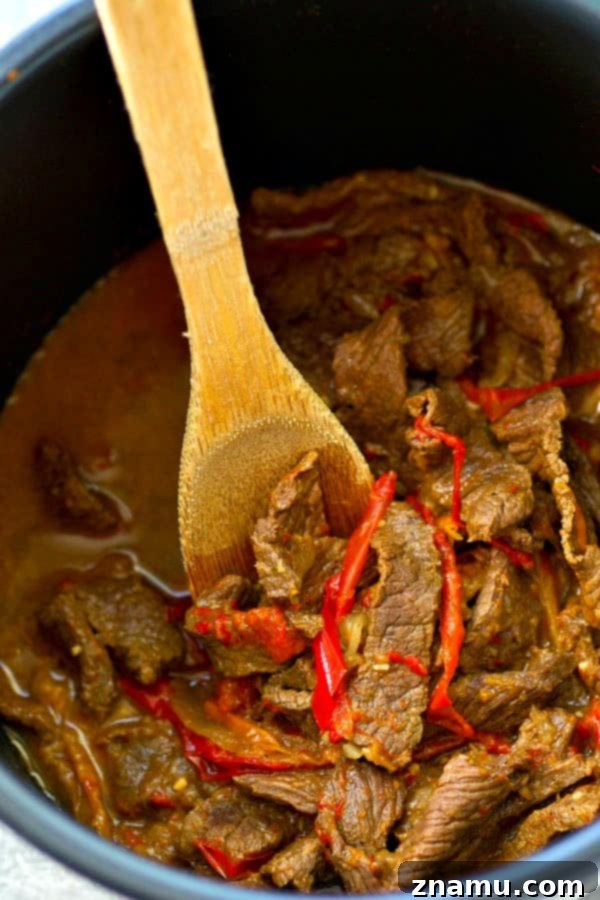 Instant Pot Fiery Beef and Bell Pepper Fajitas 4 A generous serving of Instant Pot spicy beef and sweet peppers fajitas in a warm tortilla, topped with fresh cilantro.