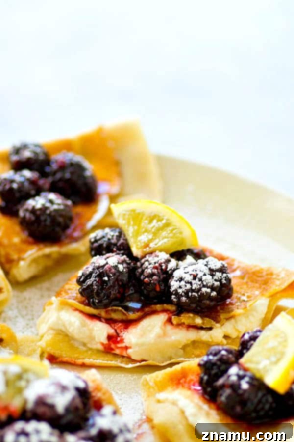 Delicious Blackberry Lemon Cream Cheese Crepes topped with fresh fruit and powdered sugar, ready for a perfect brunch