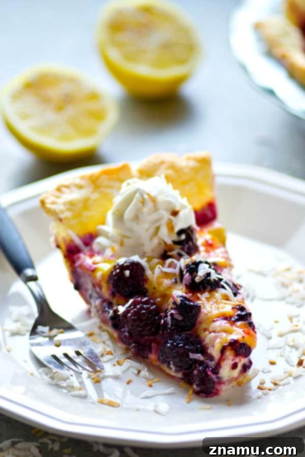 Rich coconut cream pie slice with vibrant blackberry and lemon curd layers