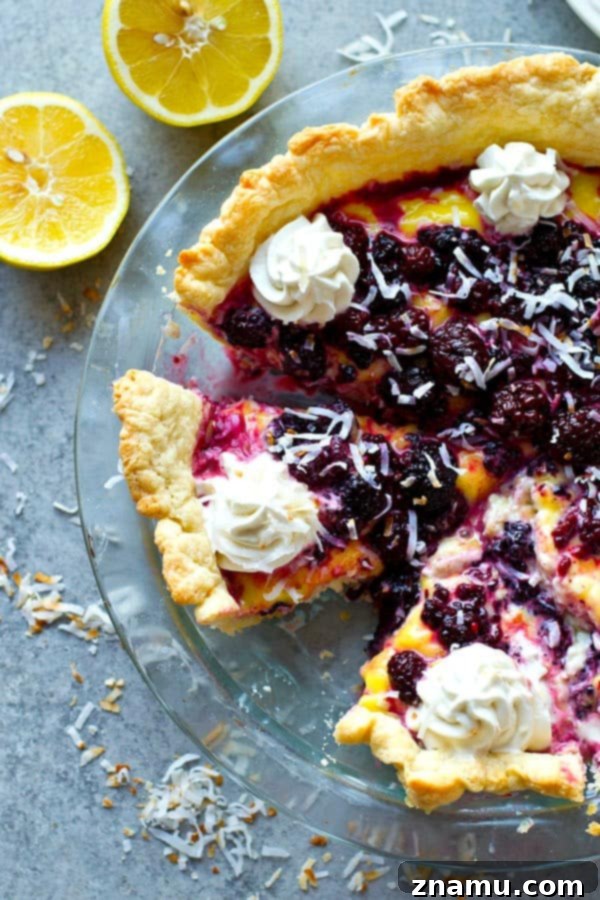 A generous slice of blackberry lemon curd coconut cream pie on a plate