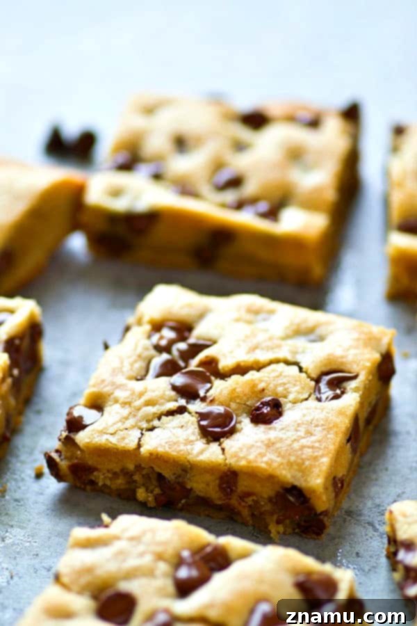 Gooey Coconut Oil Chocolate Chip Bars 3 A stack of homemade coconut oil chocolate chip cookie bars, showcasing their golden-brown edges and deliciously chewy centers.