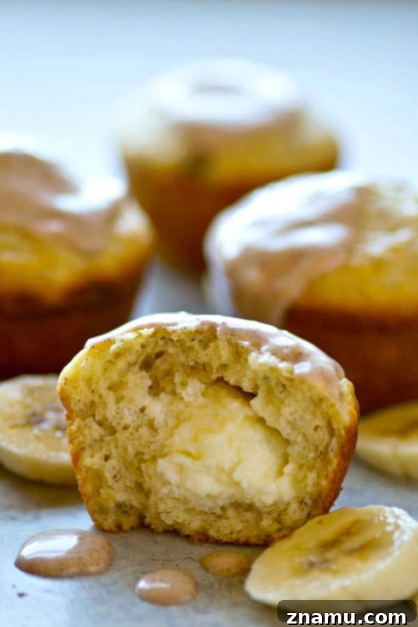 Comforting Banana Cream Cheese Muffins with Spiced Chai Glaze 4 Two banana cream cheese muffins with chai glaze, showing the inviting texture and sweet topping.