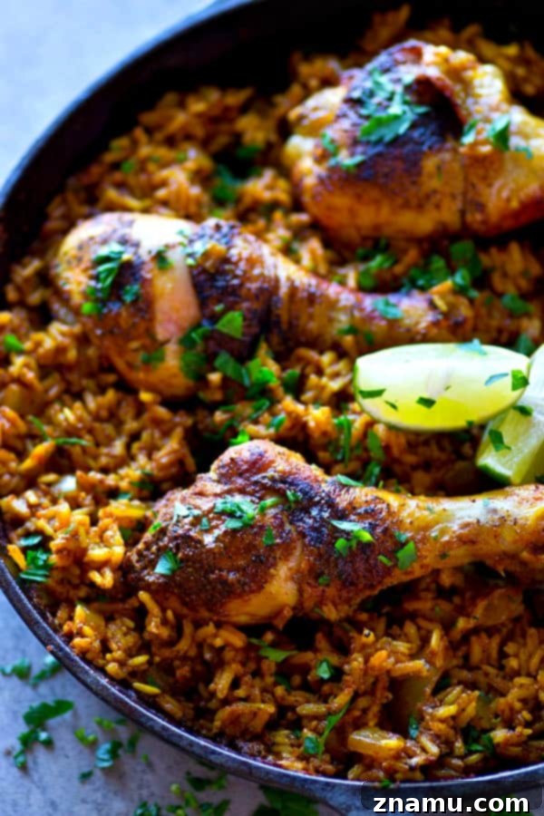 Spanish Skillet Chicken and Rice 3 A beautifully presented one-pot Spanish chicken and rice skillet, garnished with fresh cilantro and lime wedges.