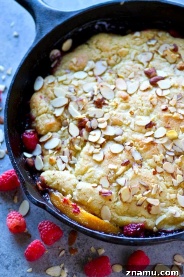 Close-up of golden brown almond topping on a Skillet Raspberry Almond Peach Cobbler