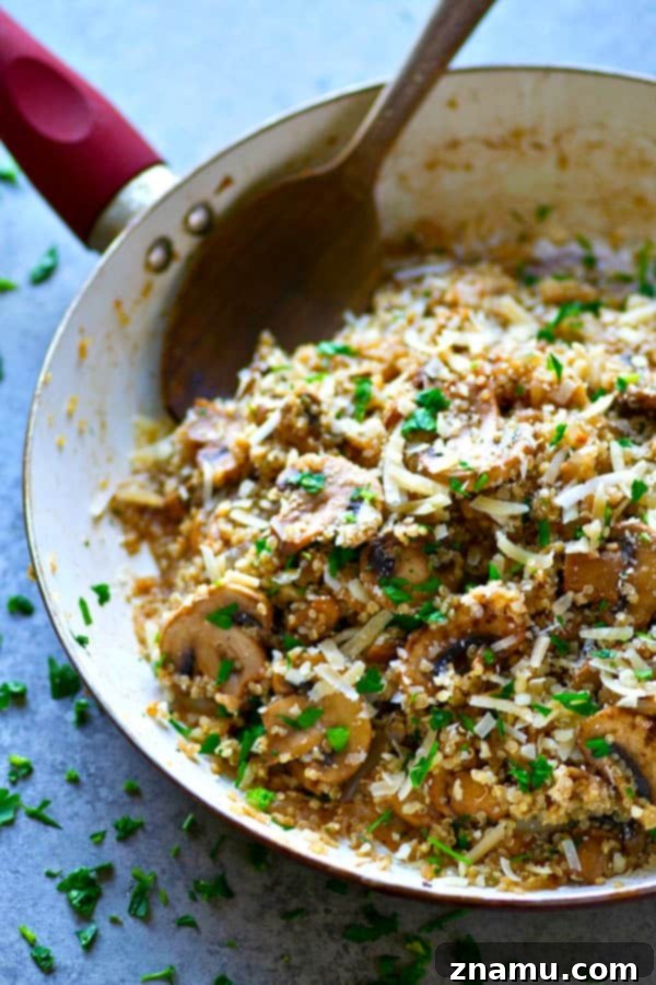 Overhead view of the Balsamic Mushroom Parmesan Quinoa Skillet, showcasing the vibrant green parsley, dark brown mushrooms, and creamy white quinoa against a rustic skillet.