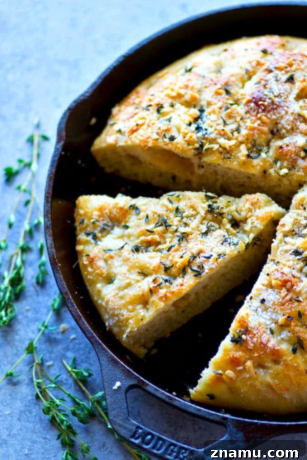 Effortless Overnight Parmesan Herb Focaccia 2 A golden-brown, soft Parmesan Herb Focaccia with dimples, fresh rosemary, and coarse salt, showcasing its perfect texture and inviting aroma. This no-knead recipe develops incredible flavor overnight.