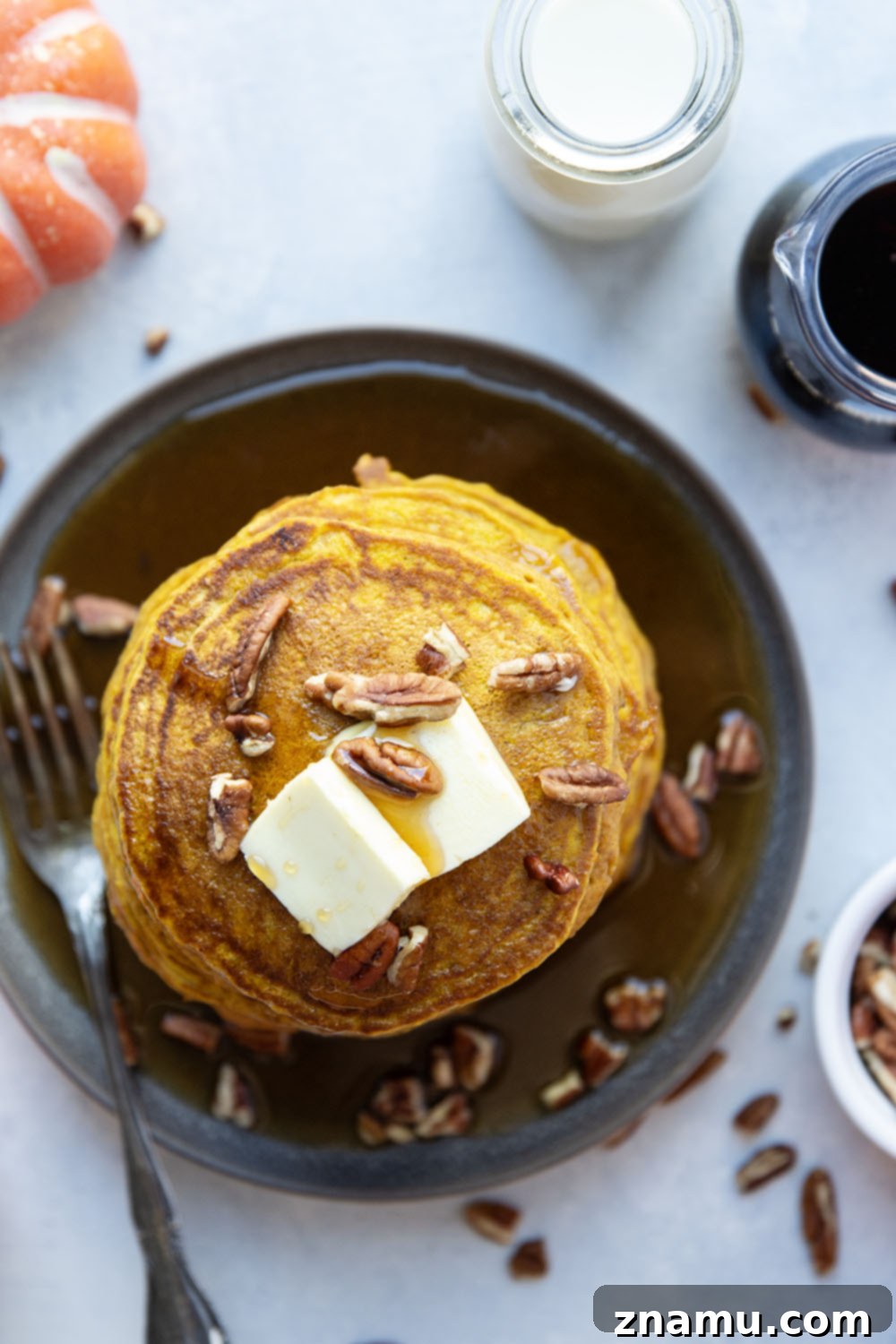 Warm Spiced Pumpkin Stacks 3 Close-up of golden brown pumpkin spice pancakes stacked high, showing their fluffy texture, with a hint of warm spices visible.