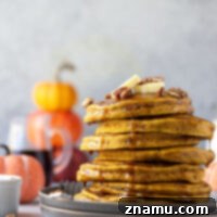 Packed with pumpkin and plenty of warm spices, these pumpkin spice pancakes are perfectly thick, fluffy and incredible with warm maple syrup and pecans on top!