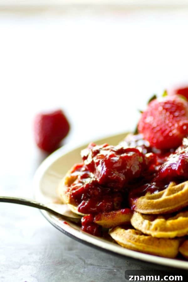 Crispy, rustic cornmeal waffles are topped with the BEST homemade strawberry preserves for the best summer breakfast you'll ever have.