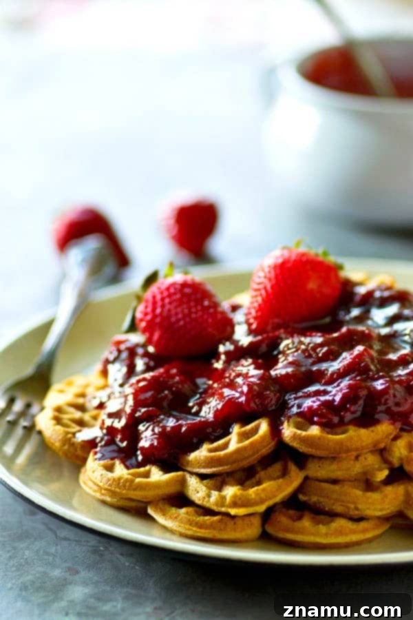 Crispy, rustic cornmeal waffles are topped with the BEST homemade strawberry preserves for the best summer breakfast you'll ever have.