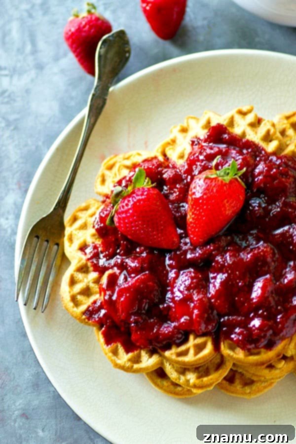 Crispy, rustic cornmeal waffles are topped with the BEST homemade strawberry preserves for the best summer breakfast you'll ever have.