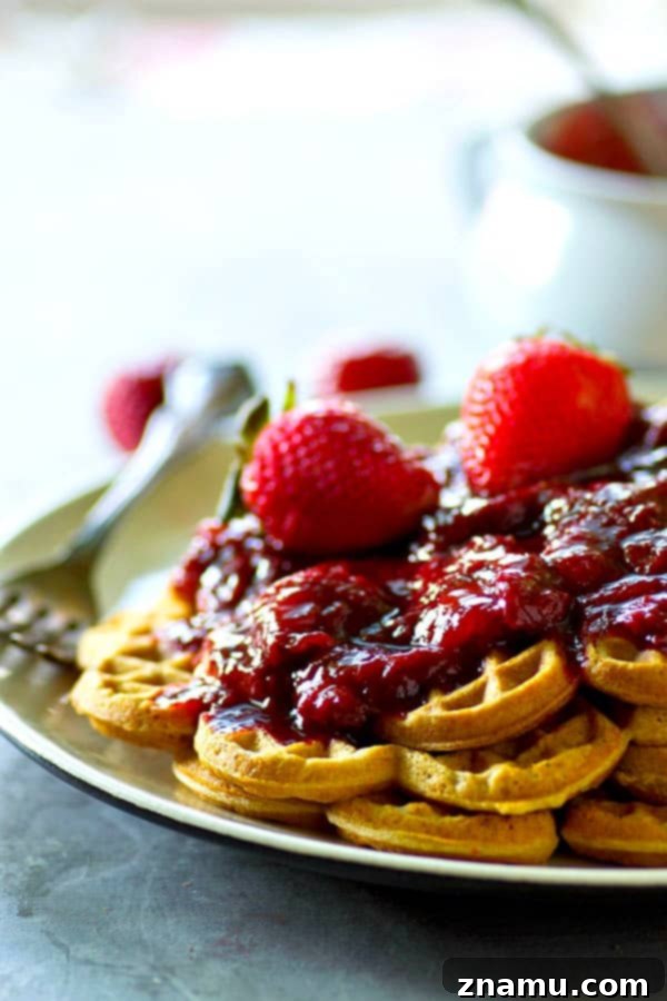 Crispy, rustic cornmeal waffles are topped with the BEST homemade strawberry preserves for the best summer breakfast you'll ever have.