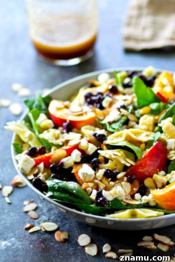 Orchard Fresh Feta Pasta Salad with Berry and Spinach 3 Close-up shot of the Feta Spinach Pasta Salad, showcasing juicy peaches, blueberries, and crumbled feta cheese.