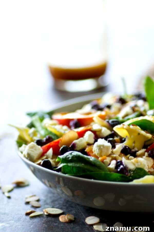 Orchard Fresh Feta Pasta Salad with Berry and Spinach 4 Overhead view of a large serving bowl filled with the colorful Blueberry Peach Feta Spinach Pasta Salad.