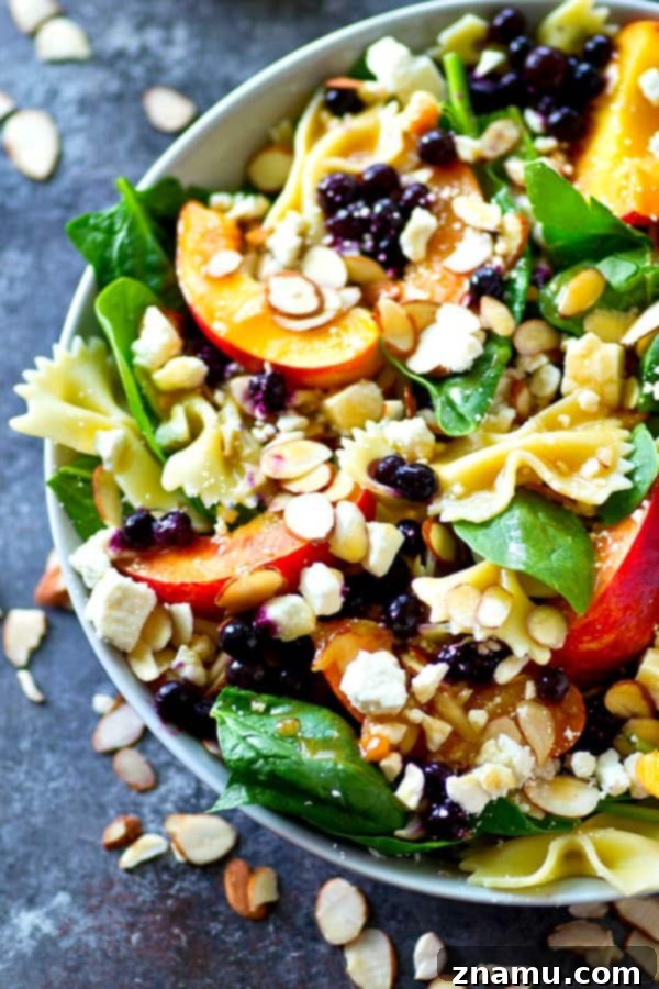 Orchard Fresh Feta Pasta Salad with Berry and Spinach 5 A close-up of the delicious Asian dressing being drizzled over the Blueberry Peach Feta Spinach Pasta Salad.