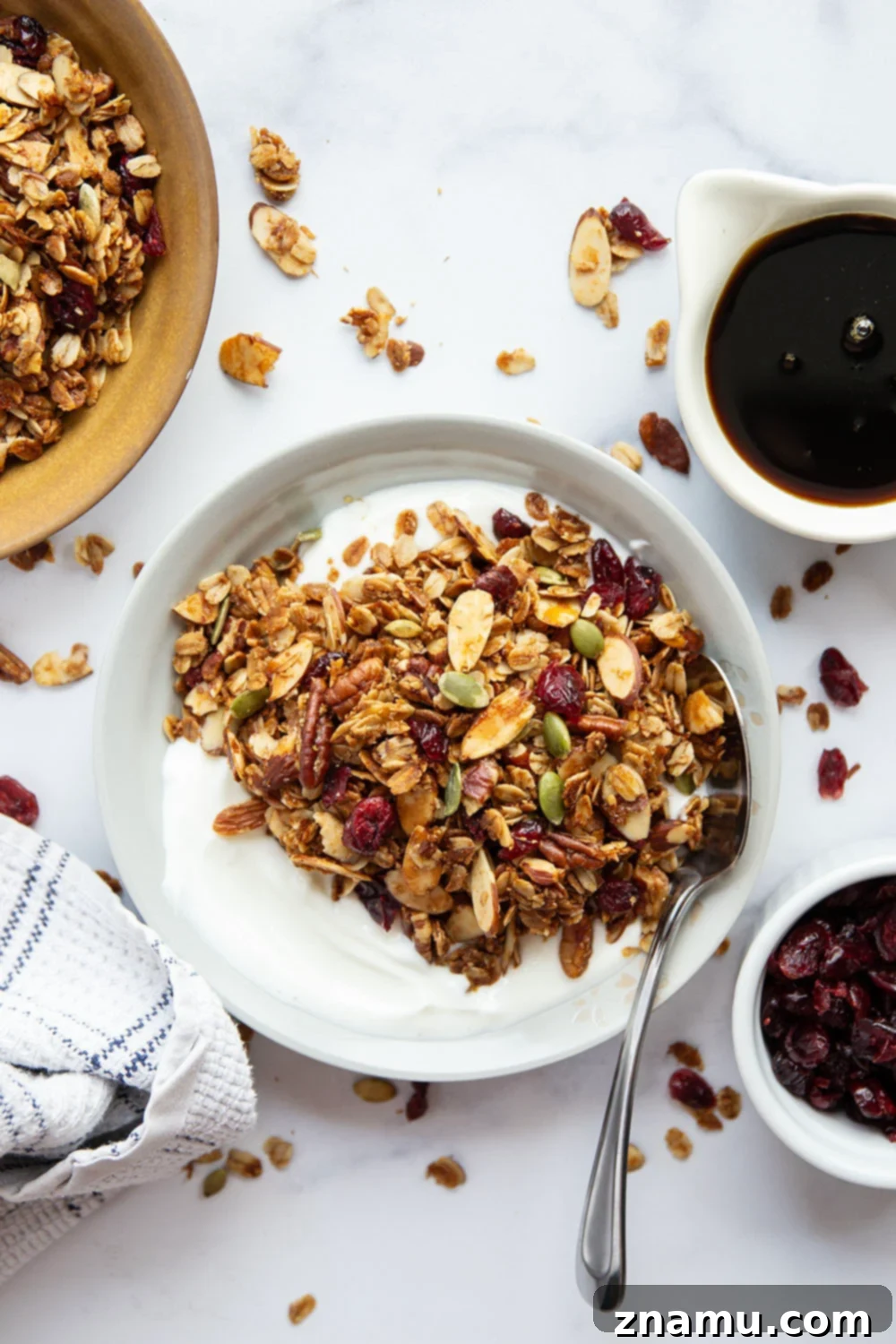 Sweet Maple Crunch 4 A bowl of fresh maple granola, invitingly crunchy, with a spoon ready to serve.
