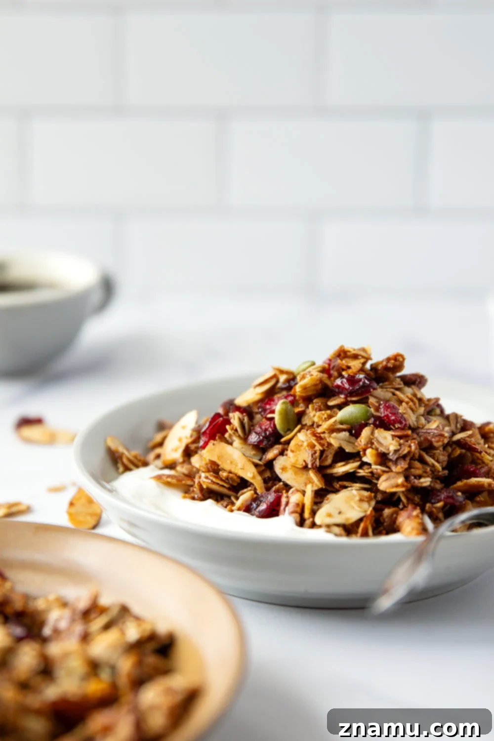 Sweet Maple Crunch 5 Ingredients for maple granola laid out on a table: oats, nuts, maple syrup, coconut oil, and dried cranberries.