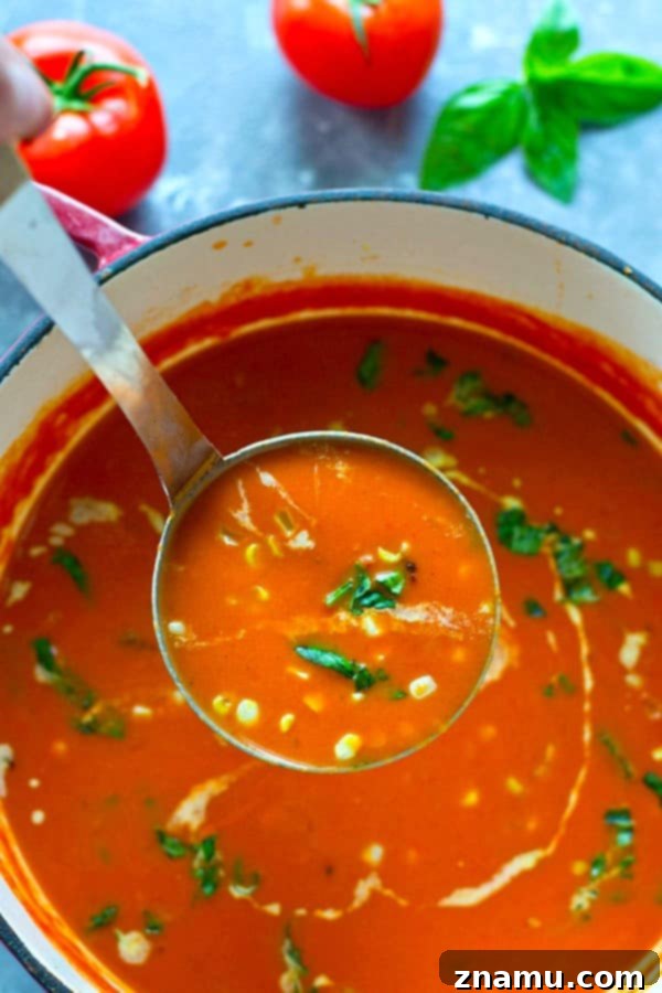 Sun-Kissed Tomato-Basil Soup with Charred Sweet Corn 3 Fresh, ripe garden tomatoes and fragrant basil leaves on a wooden board.
