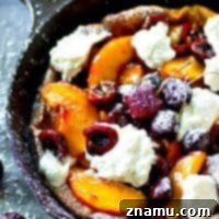 Fluffy honey whipped cream and juicy summer cherries and peaches are piled high into this summery cherry peach dutch baby that's ready in 30 minutes flat!