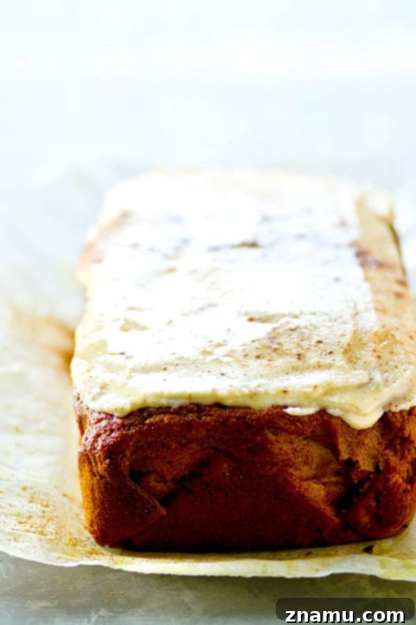 Nutty Brown Butter Pumpkin Loaf with Creamy Glaze 3 Close-up of a slice of Frosted Browned Butter Pumpkin Bread on a plate, highlighting its moist texture and rich frosting