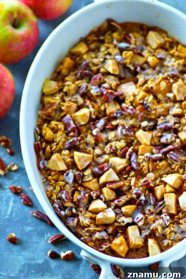 Apple Pie Oatmeal Bake 3 Close-up shot of a serving of Glazed Apple Pie Baked Oatmeal with a spoon, showing its fluffy texture and sweet glaze.